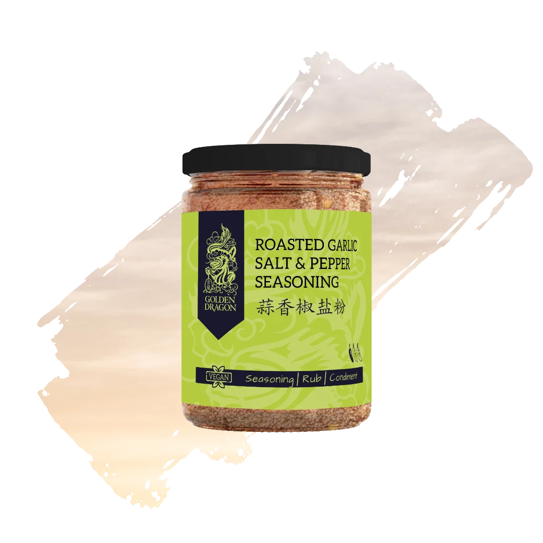A glass jar of Golden Dragon Roasted Garlic Salt and Pepper Seasoning with a lime green label, featuring a black dragon logo and a "Vegan" certification mark.